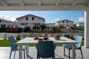una mesa blanca y sillas en un patio en Residence Salinelle Beach Villa Salina 5, en Lascari