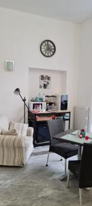 a living room with a table and a clock on the wall at le ginestre in centro in Salerno