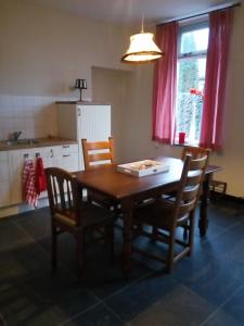 uma cozinha com uma mesa de madeira e cadeiras num quarto em Vakantiehuis In het Voorhuis em Dommelen