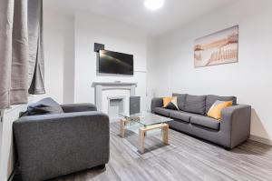 sala de estar con 2 sofás y chimenea en Pleasant Hill - TV in every Bedroom! en Swansea