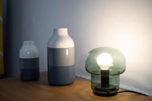two bottles and a light on a wooden table at Work-Ready Stay - Central - Parking & Smart TVs in Swansea