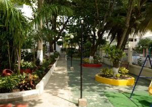 un parque con árboles, plantas y luces de la calle en Hotel Bahia Cartagena, en Cartagena de Indias