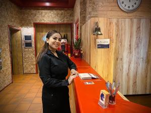a woman standing in front of a red counter at Meister BÄR HOTEL Fichtelgebirge in Marktredwitz