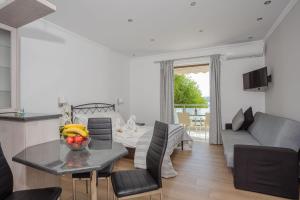 a living room with a table with a bowl of fruit on it at Mare Vita Apartments in Nydri