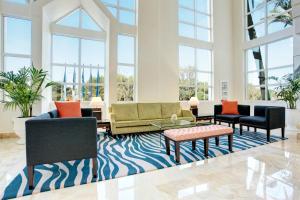 a lobby with couches and chairs and windows at Grupotel Parc Natural & Spa in Playa de Muro