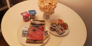 a white table with food and a vase of flowers at Center Diamond in Târgu-Mureş