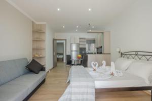 a living room with a couch and a kitchen at Mare Vita Apartments in Nydri