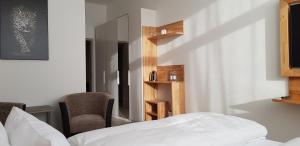 a bedroom with a bed and two chairs and a mirror at HB 32 Metzingen in Metzingen