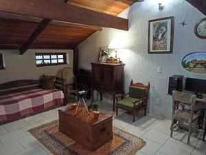 a bedroom with a bed and a table and chairs at Hospedagem Braga - acomodação domiciliar in Cunha