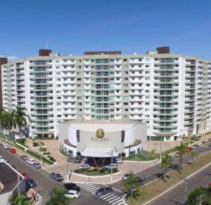 een groot wit gebouw met een parkeerplaats ervoor bij Riviera park Thermas Flat 1 in Caldas Novas