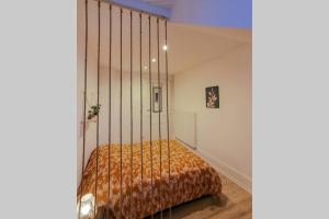 a bedroom with a bed with a orange blanket at Appart'Hôtel Le Strasbourg - RENOVÉ, CALME ET NETFLIX in Belfort