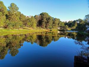 a river with trees reflecting in the water at Hospedagem Braga - acomodação domiciliar in Cunha
