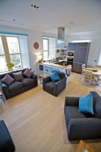 a living room with two couches and a kitchen at Northlight Apartments - The Loom in Orkney