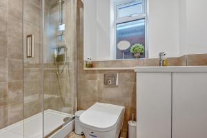 a bathroom with a toilet and a shower and a sink at St Martins House Luxury 2 Bedroom Apartments Ruislip By 360Stays in Ruislip