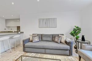 a living room with a couch and a kitchen at St Martins House Luxury 2 Bedroom Apartments Ruislip By 360Stays in Ruislip
