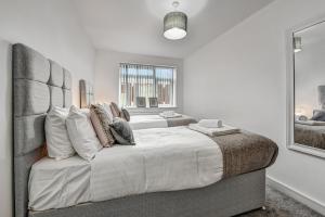 a bedroom with two beds with white walls and a window at St Martins House Luxury 2 Bedroom Apartments Ruislip By 360Stays in Ruislip