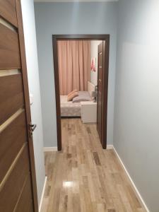 ein kleines Schlafzimmer mit einem Bett und einem Spiegel in der Unterkunft Apartament Szary in Świnoujście