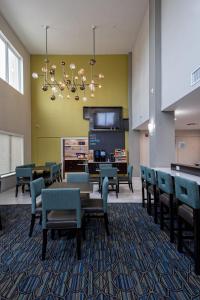 a waiting room with chairs and a table and a kitchen at Holiday Inn Express Hotel and Suites Port Aransas/Beach Area, an IHG Hotel in Port Aransas