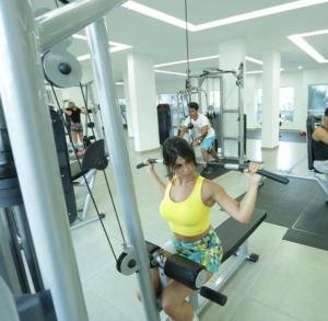 Een vrouw in een sportschool die kraakt op een machine. bij Riviera park Thermas Flat 1 in Caldas Novas
