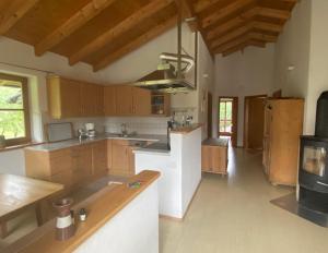 a large kitchen with wooden cabinets and a stove at Ferienwohnungen Wolfgang Geistanger in Siegsdorf