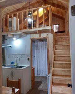 a kitchen and staircase in a tiny house at Casa de Noah Bed & Breakfast in Pucón