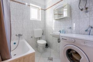 a white bathroom with a washing machine in it at Apartments KULAS in Novi Vinodolski +58 photos