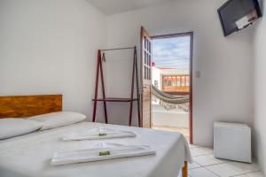 a bedroom with a bed with two towels on it at Convés Pousada in Barra de São Miguel