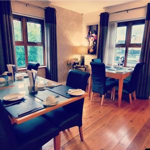 a dining room with a wooden table and blue chairs at Church View House in Gorteen