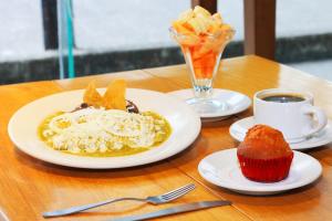 una mesa con platos de comida y una magdalena y café en Hotel Central en Veracruz