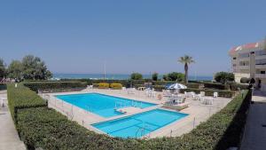 a swimming pool in a resort with chairs and a building at ERICE BEACH MARE DELUX in Erice