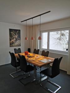 a dining room with a wooden table and chairs at Ferienwohnung Pontresina - Chesa Andrea - Gartensitzplatz in Pontresina