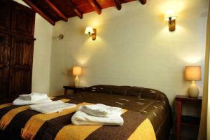 1 dormitorio con 1 cama con toallas en Cabanias El Aguaribay en San Javier