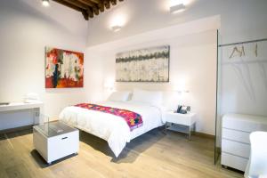 a white bedroom with a bed and a table at Domingo Santo Hotel Boutique in Mexico City