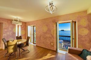 a dining room with a table and a view of the ocean at Apartments Galija Petrovac Lux in Petrovac na Moru