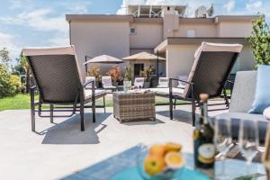 a patio with two chairs and a table with a bottle of wine at Apartments Bego Spa & Wellness in Crikvenica