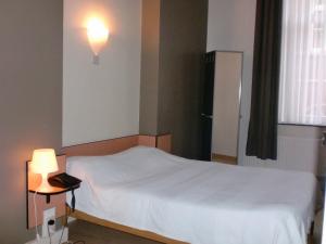 Postel nebo postele na pokoji v ubytování Hôtel Les Acteurs