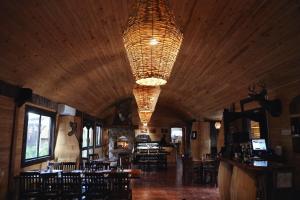 a dining room with tables and chairs and a chandelier at Hotel Valle 13 Ruta del Vino in Valle de Guadalupe