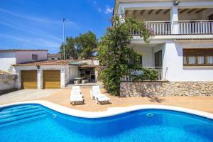 a villa with a swimming pool in front of a house at Spacious Apartment in Canyelles with Private Pool in Canyelles