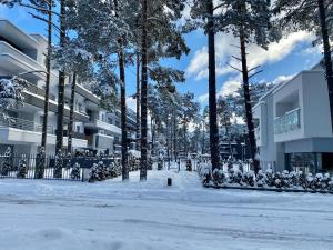 una calle cubierta de nieve con árboles y edificios en Apartament Jula 2 en Pogorzelica
