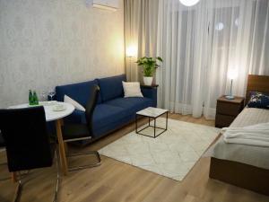a living room with a blue couch and a table at Studio nr 2 close to Medicover and Paley Institute in Warsaw