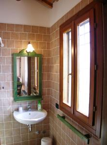 a bathroom with a sink and a mirror and a window at Agriturismo Zennare in Chioggia