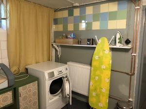 a small kitchen with a washing machine and a washer at Dala Cottage in Ulriksberg