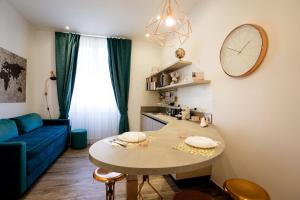- un salon avec une table et un canapé bleu dans l'établissement Apartments and Suites 5 Terre La Spezia, à La Spezia