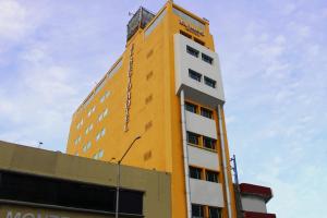 un edificio amarillo con un reloj encima en El Regio en Monterrey