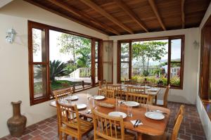 a dining room with a table and chairs and windows at Ocean View Happy Hill in Olón