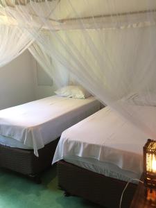 Giường trong phòng chung tại Cores do Mar Cabanas, Taipu de Fora