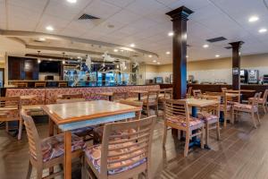 an empty restaurant with wooden tables and chairs at Best Western Downtown Stuart in Stuart