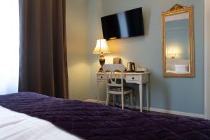 a bedroom with a bed and a desk and a mirror at Best Western Hotel Bentleys in Stockholm