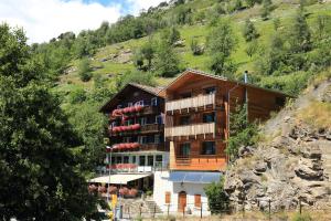 un edificio su una collina con una montagna di VISPERBLICK 24-7 Parkplatz und Frühstück inkl ad Ausserberg