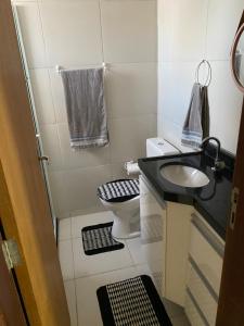 een kleine badkamer met een wastafel en een toilet bij Residencial Havaí in João Pessoa